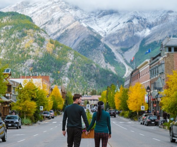 Banff village in Banff national park Canada Canadian Rockies during Autumn fall season. Couple of men and women on vacation in Banff Canada between the mountains